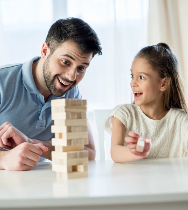 ojciec grający z córką w grę jenga