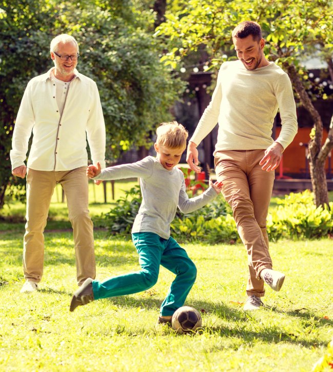 ojciec, syn i dziadek grają w piłkę w ogrodzie