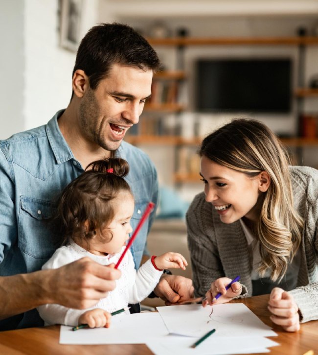 rodzice bawiący się w rysowanie z małą córką
